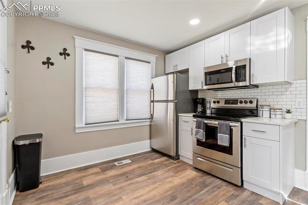 Image 15 of 43: Kitchen with appliances with stainless steel finishes, light wood finished 