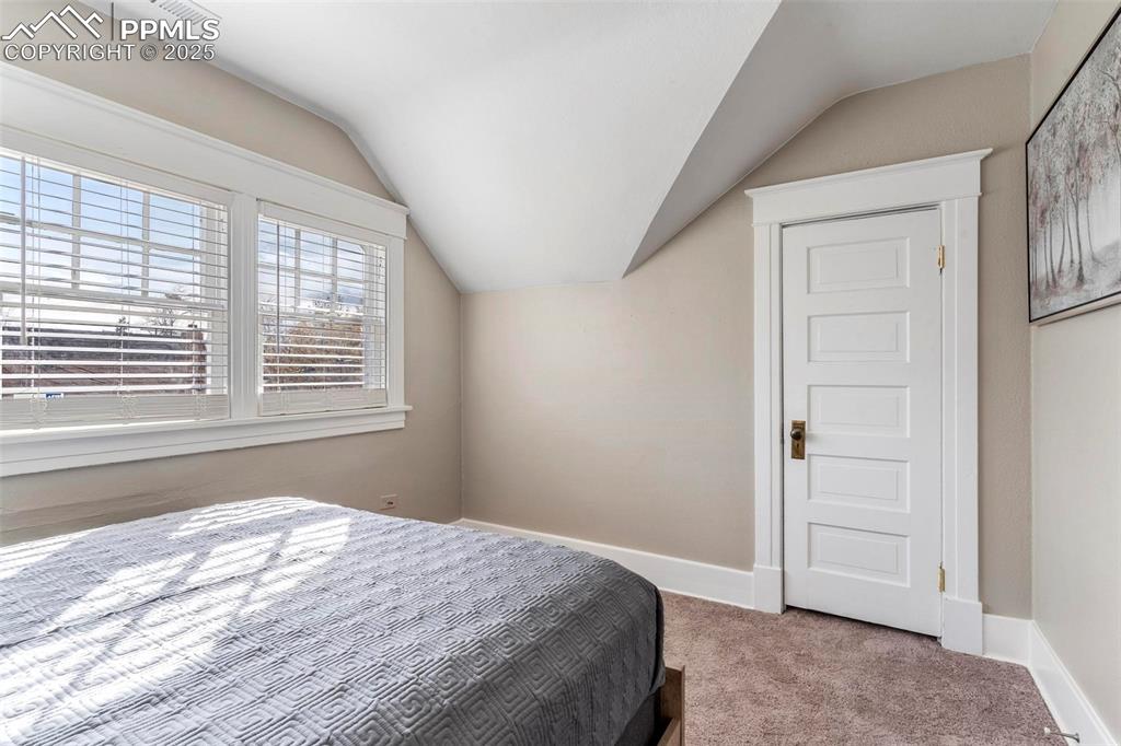 Image 23 of 43: Carpeted bedroom featuring vaulted ceiling and baseboards