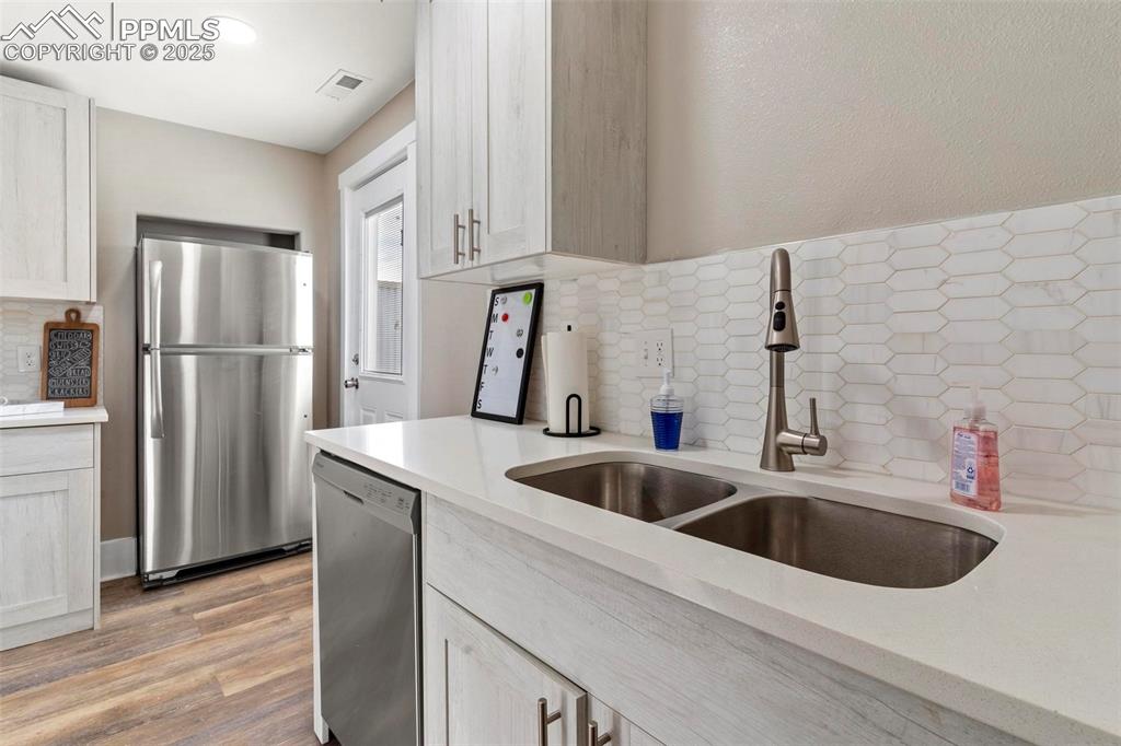 Image 28 of 43: Kitchen featuring stainless steel appliances, a sink, light countertops, an