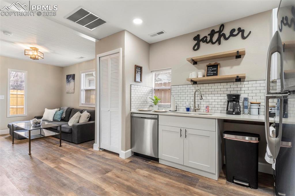 Image 38 of 43: Kitchen with stainless steel appliances, a sink, backsplash, wood finished 