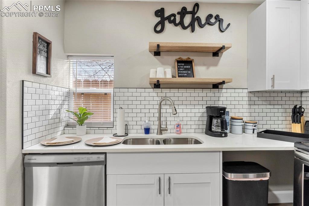 Image 40 of 43: Kitchen featuring dishwasher, a sink, decorative backsplash, light countert