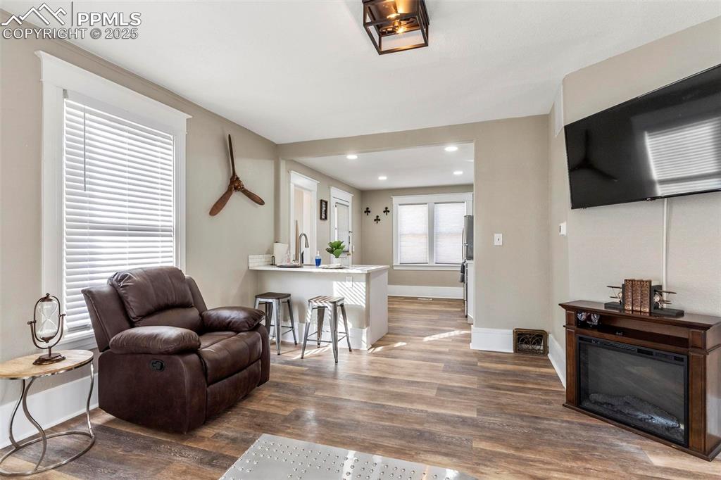 Image 9 of 43: Living area featuring wood finished floors, baseboards, and recessed lighti