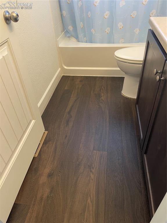 Image 14 of 25: Full bath with vanity, shower / bath combo, and dark wood-style flooring