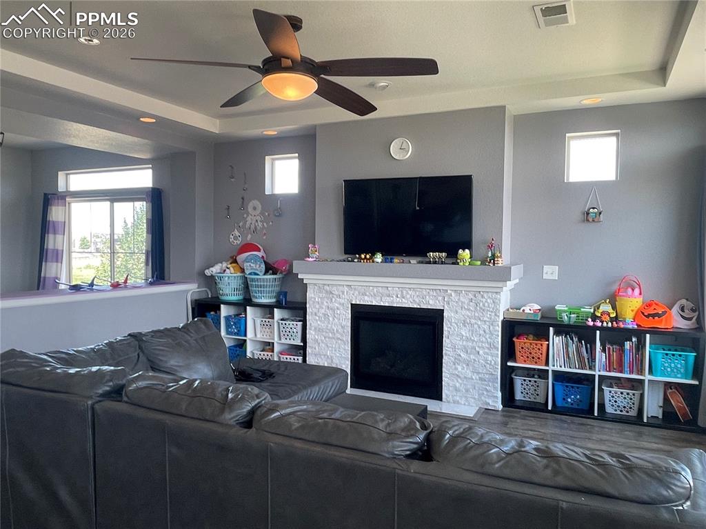 Image 8 of 25: Living room with ceiling fan, healthy amount of natural light, a raised cei
