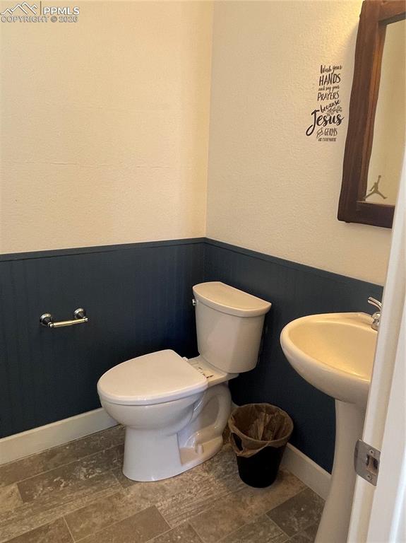 Image 9 of 25: Half bath featuring a wainscoted wall