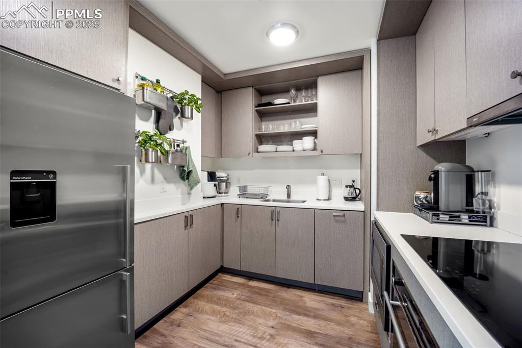 Image 25 of 50: Kitchen with appliances with stainless steel finishes, light countertops, l