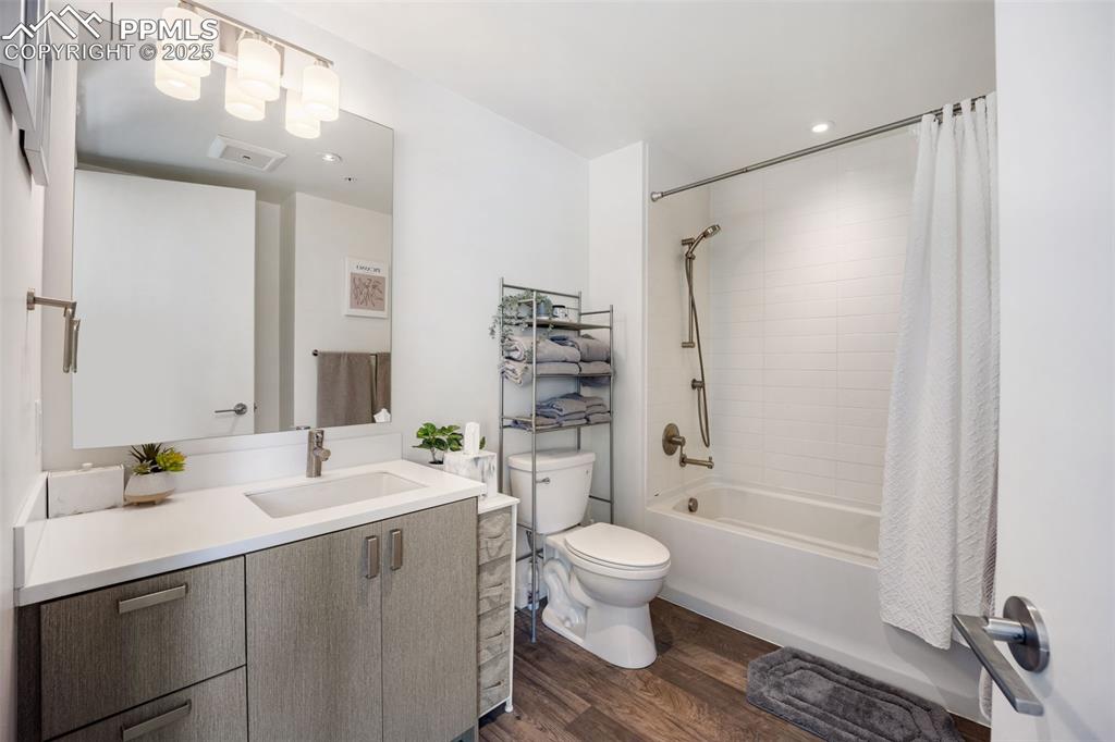 Image 38 of 50: Full bathroom with vanity, shower / tub combo with curtain, and dark wood-s
