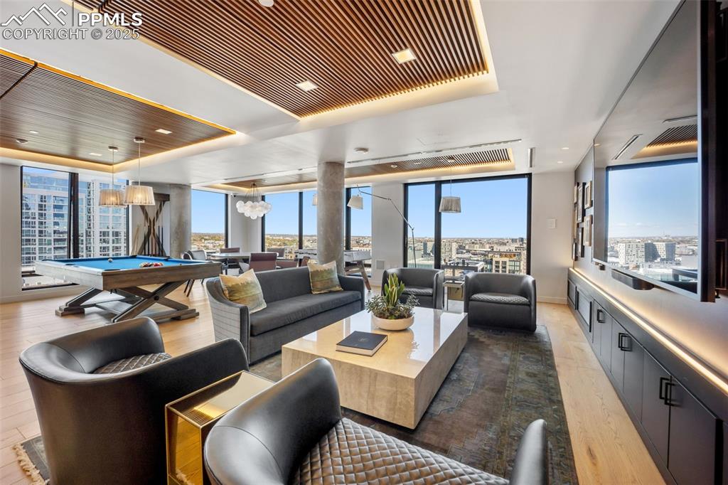 Image 4 of 50: Common area Living room featuring a tray ceiling, expansive windows, light