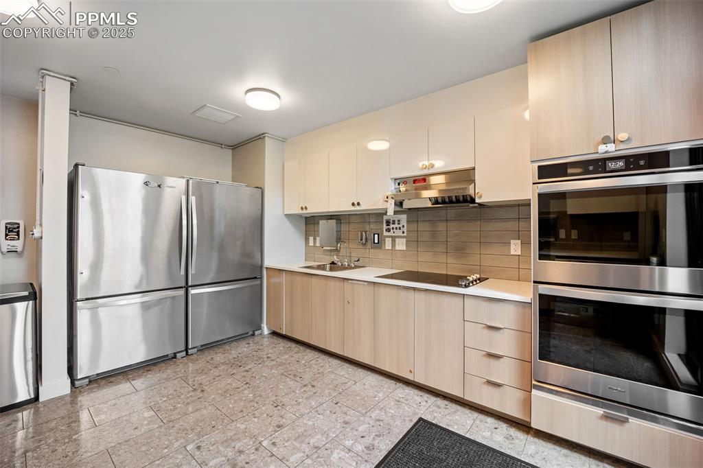 Image 44 of 50: Owners Lounge Kitchen with appliances with stainless steel finishes, light