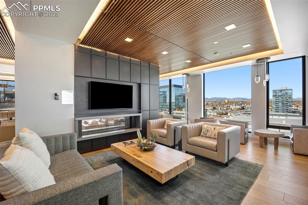 Image 6 of 50: Owners Lounge living area with a multi sided fireplace, dark wood-type floo