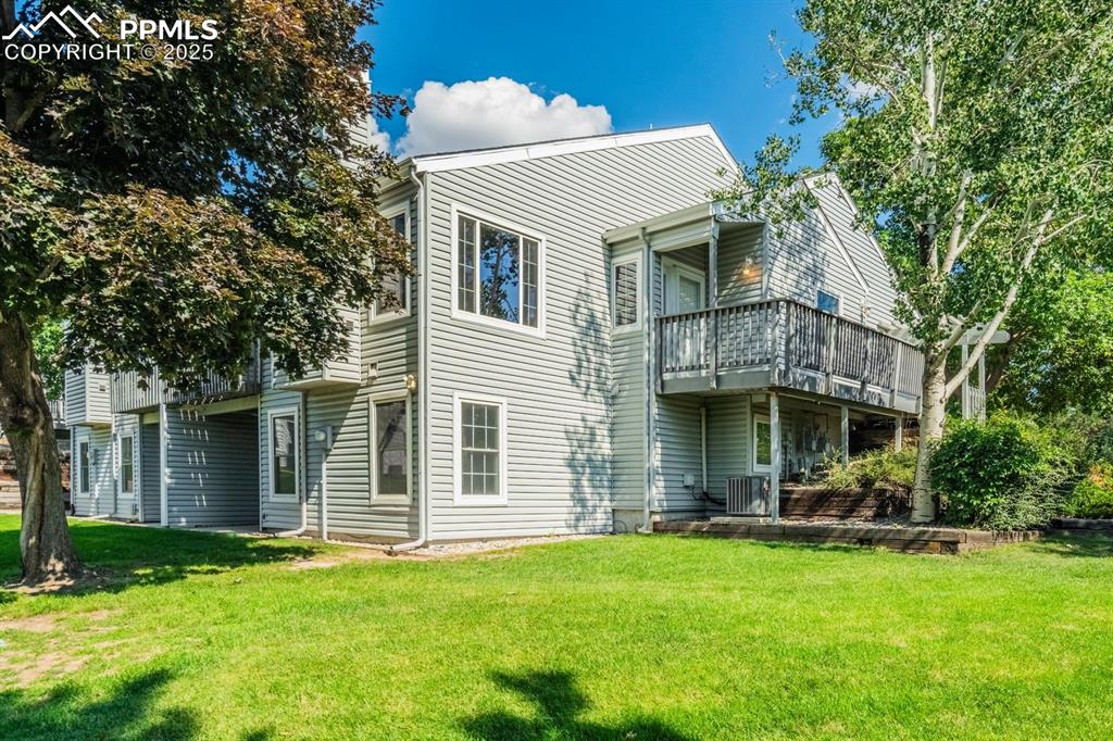 Image 9 of 41: Back of house featuring a green space and composite deck.