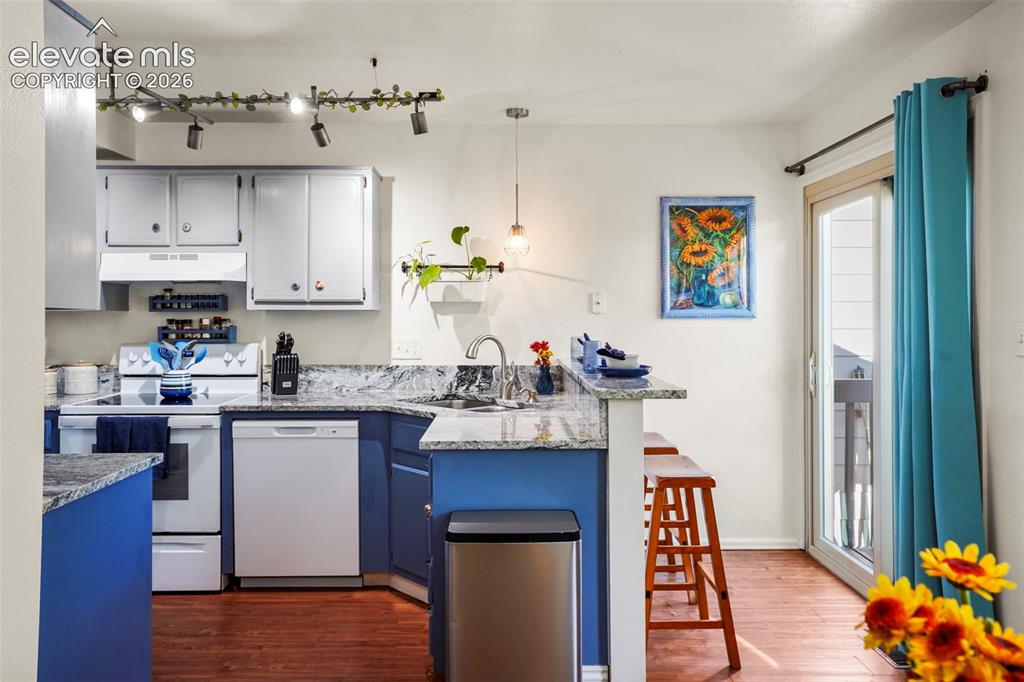 Image 10 of 28: Kitchen featuring multi-tone cabinetry, stone-surface countertops, wood-fin