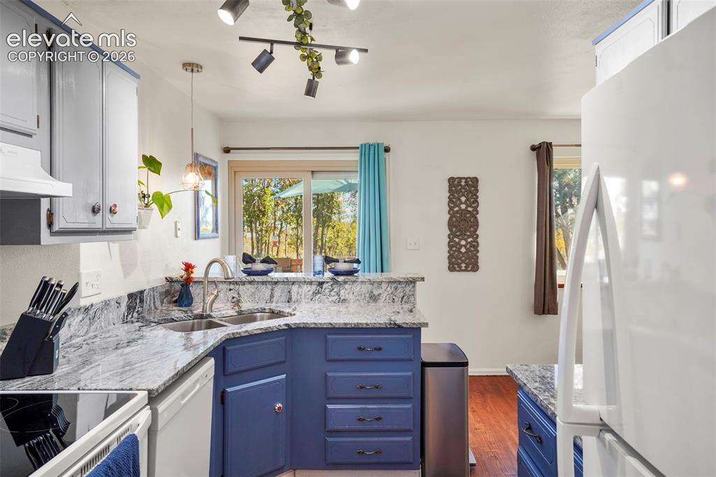 Image 12 of 28: Kitchen featuring stone-finish countertops, stainless steel dual-basin sink