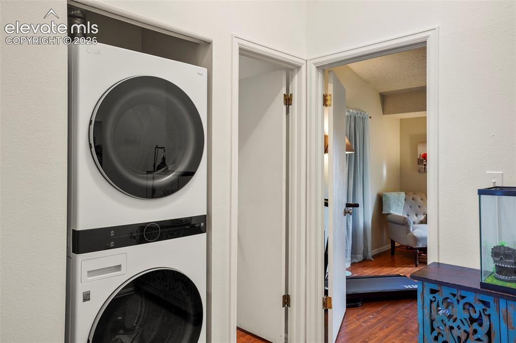 Image 16 of 28: Stacked laundry unit with front-loading washer and dryer, finished with smo