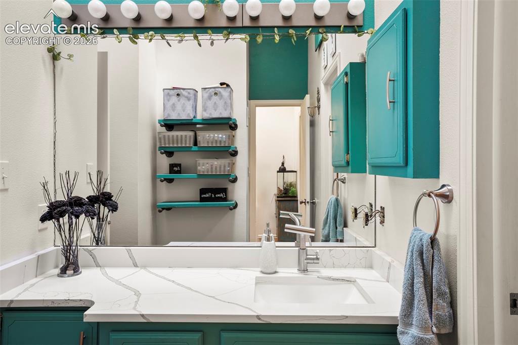 Image 19 of 28: Bathroom vanity featuring a stone-composite countertop with integrated rect