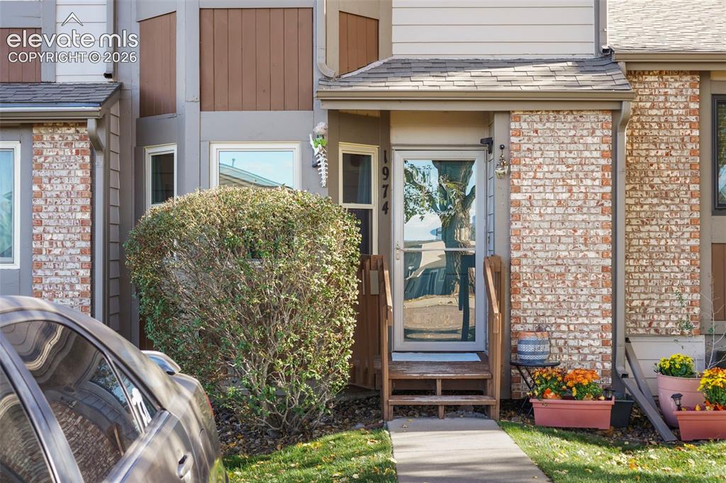 Image 2 of 28: Exterior facade featuring multi-textured brick and siding, a covered entry,