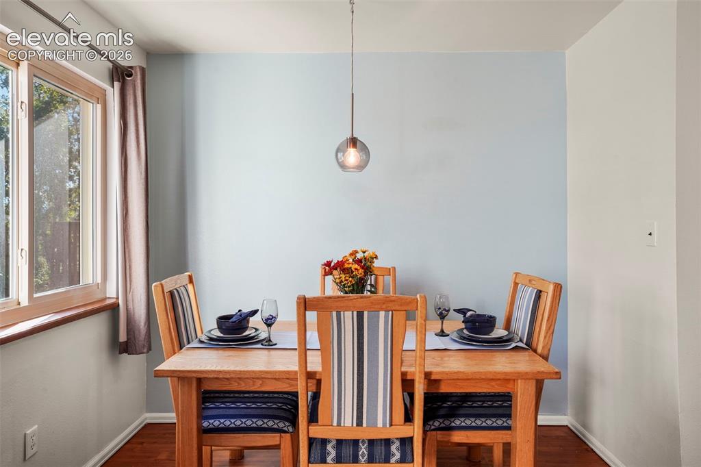 Image 9 of 28: Dining area featuring wood-finish flooring, a light-filled window with a wo