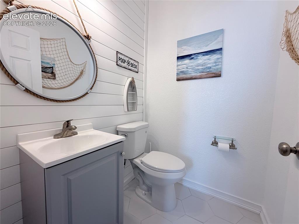 Image 10 of 22: White shiplap accent wall, hexagonal tile flooring, vanity with integrated
