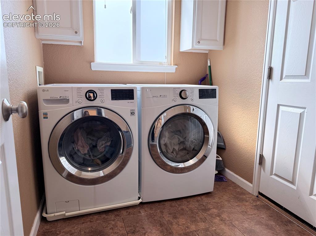 Image 11 of 22: Laundry area featuring a window, overhead cabinetry, and wood-finish floori