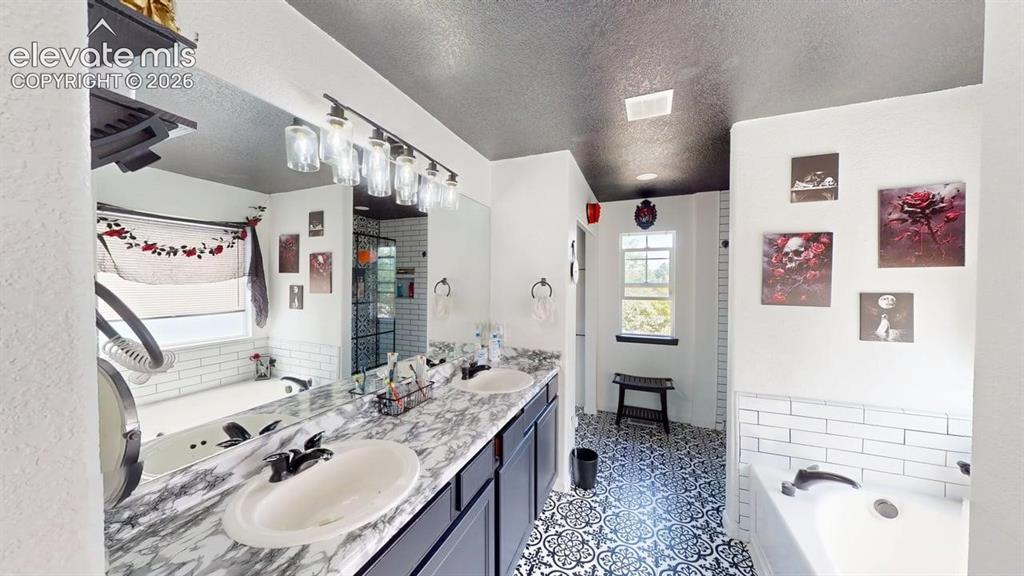 Image 15 of 22: Dual vanity with oval sinks and a marble-finish countertop