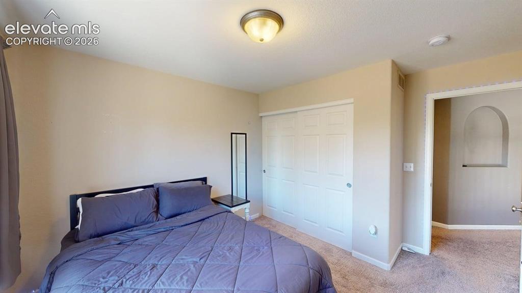 Image 17 of 22: Room featuring neutral wall tones, textured carpeting, and a built-in close