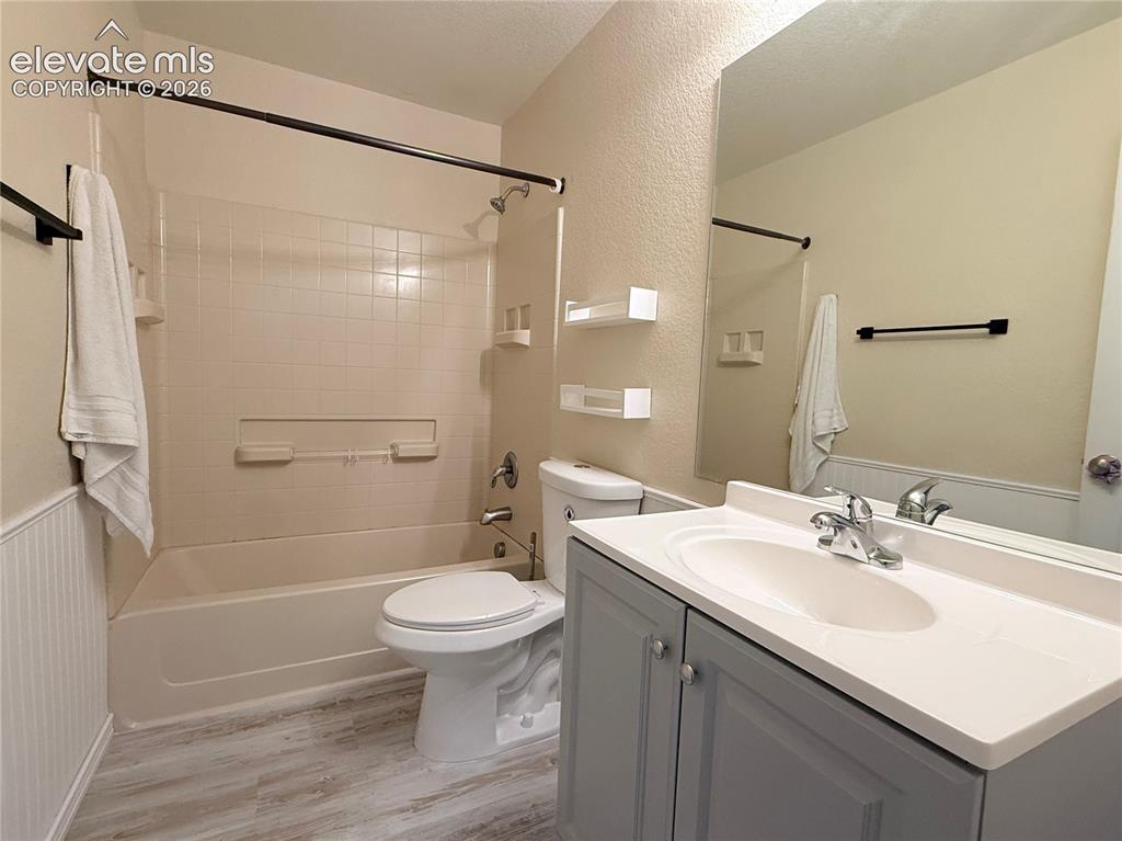 Image 18 of 22: Full bathroom featuring a tub/shower combination with tiled surround, a toi