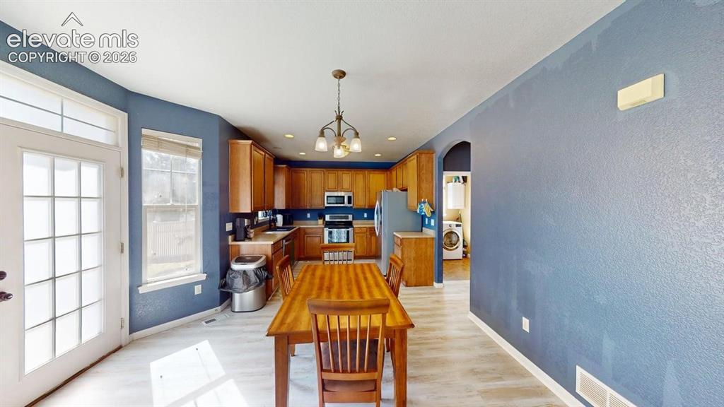 Image 6 of 22: Kitchen with wood-finish flooring, recessed lighting, and a metal chandelie