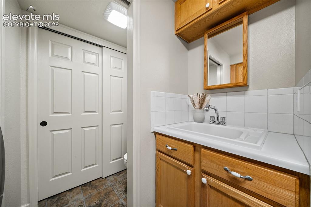 Image 22 of 30: Main level bedroom with window seat and storage