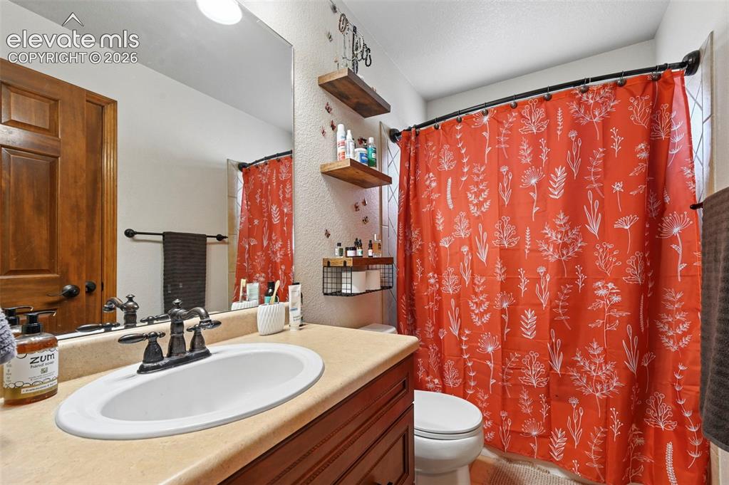 Image 11 of 34: Bathroom vanity featuring a drop-in sink with a dark bronze faucet, a light