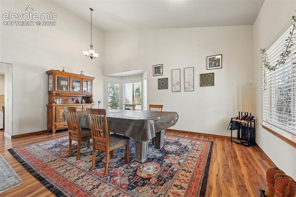 Image 27 of 34: Vaulted ceiling with an overhead light fixture, wood-finish flooring, and a