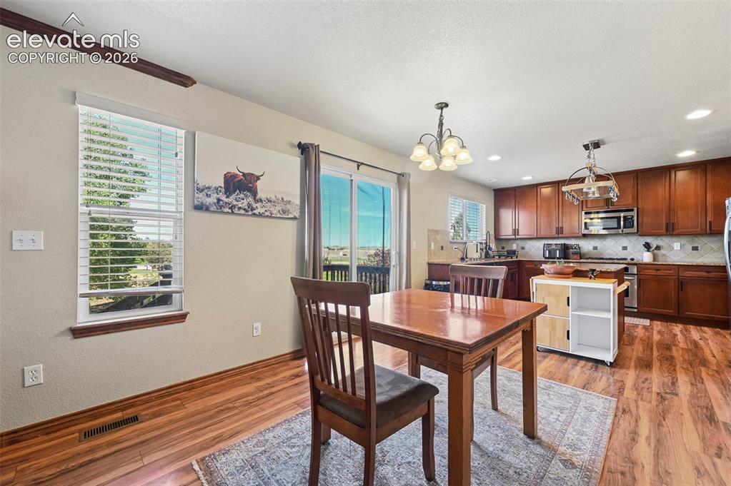 Image 3 of 34: Open-concept kitchen and dining area featuring wood-finish flooring, recess