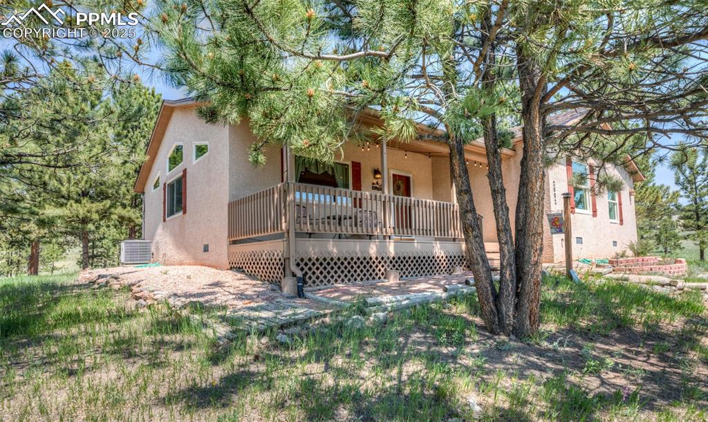 Image 10 of 48: Covered front porch and side yard.