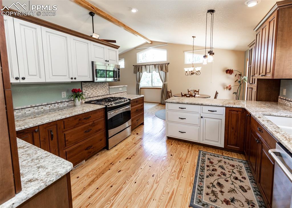 Image 18 of 48: Dual tone cabinetry brings interest and a country vibe. Knotted pine floori
