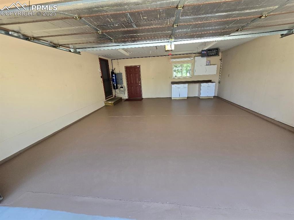 Image 38 of 48: Heated attached garage with work area. Has newly painted floors and attic s