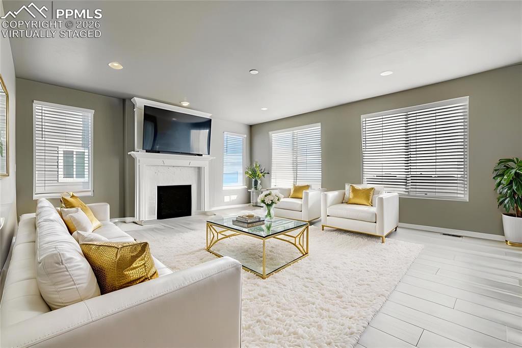 Image 14 of 35: Virtually staged main level living room featuring a fireplace, light wood-s