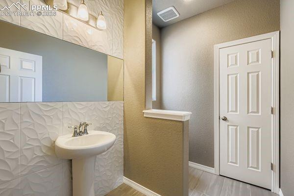 Image 18 of 35: Bathroom featuring a textured wall and baseboards
