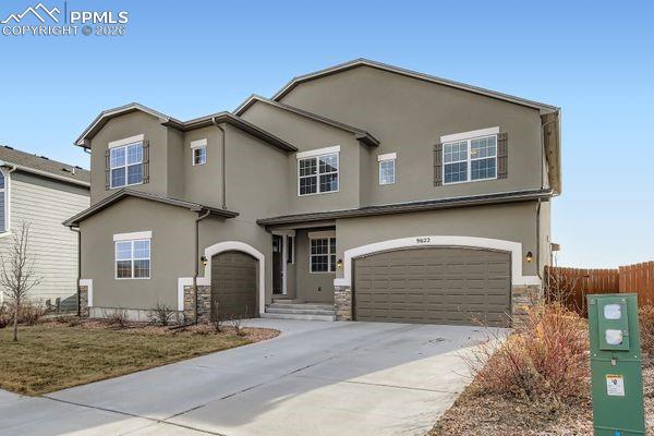 Image 2 of 35: Traditional home featuring an attached garage, stucco siding, and concrete 