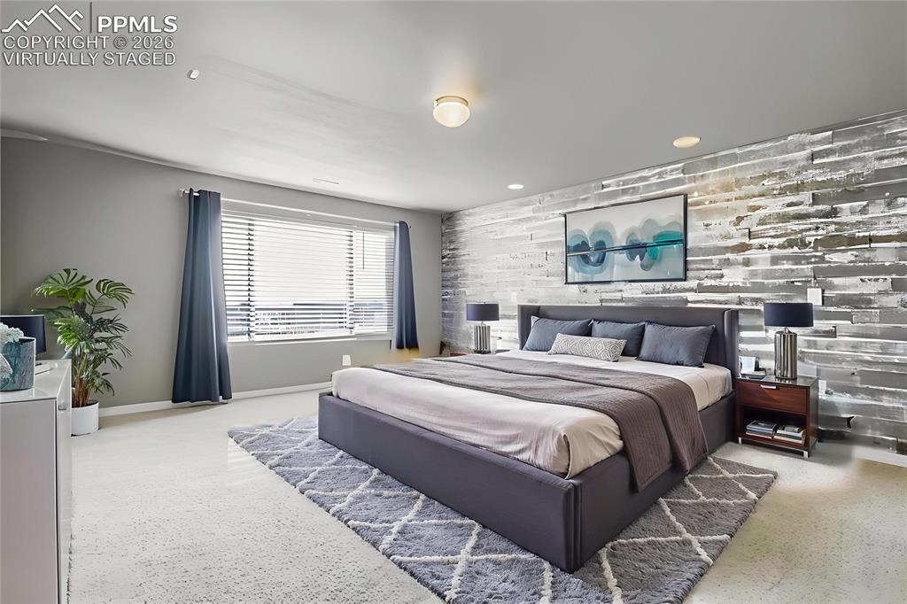 Image 21 of 35: Virtually staged primary bedroom featuring an accent wall, wood walls, and 