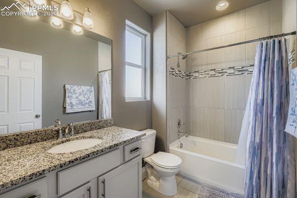 Image 26 of 35: Full bathroom featuring shower / bath combo with shower curtain, vanity, an