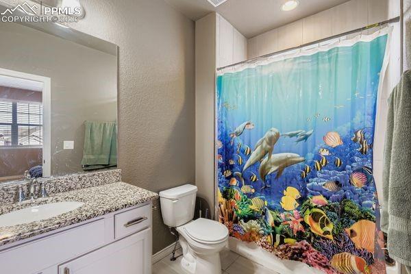 Image 27 of 35: Full bath featuring vanity, a textured wall, shower / tub combo, and tile p