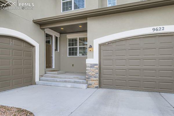 Image 3 of 35: View of exterior entry featuring stucco siding, stone siding, concrete driv
