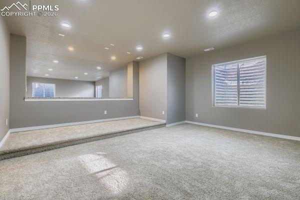 Image 33 of 35: Carpeted empty room featuring plenty of natural light and recessed lighting