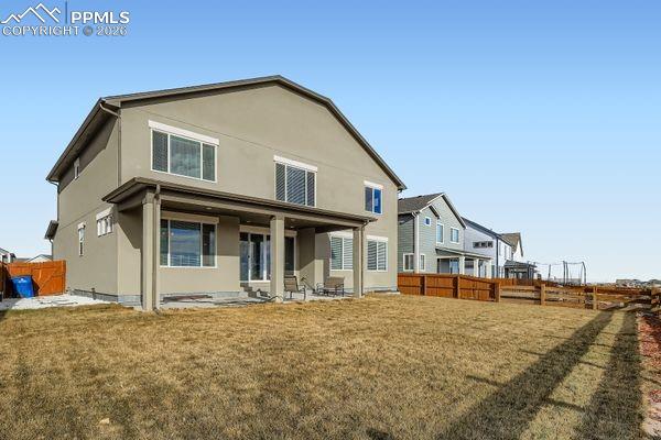 Image 34 of 35: Back of house with a fenced backyard, a patio area, and stucco siding