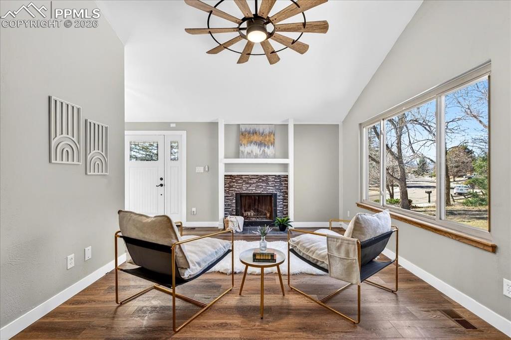 Image 11 of 49: Living area featuring wood finished floors, a tile fireplace, ceiling fan,