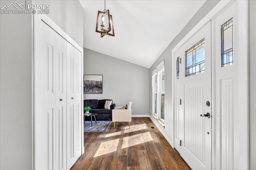 Image 13 of 49: Foyer entrance featuring lofted ceiling, dark wood finished floors, and han