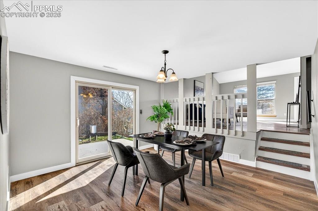 Image 22 of 49: Dining space with wood finished floors and a chandelier