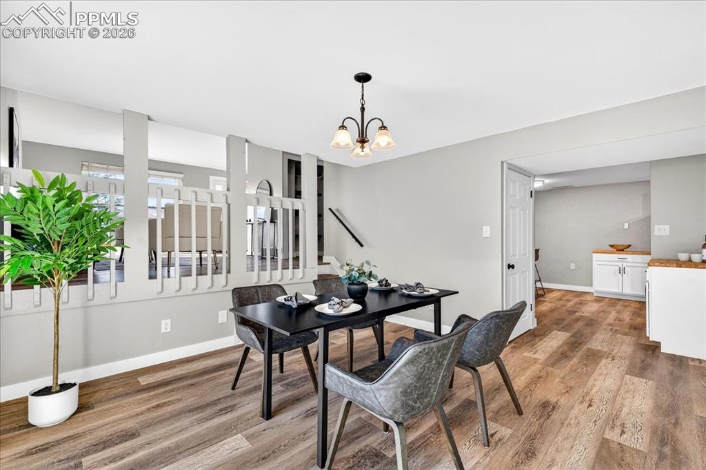 Image 23 of 49: Dining space with light wood-style floors and suspended lighting