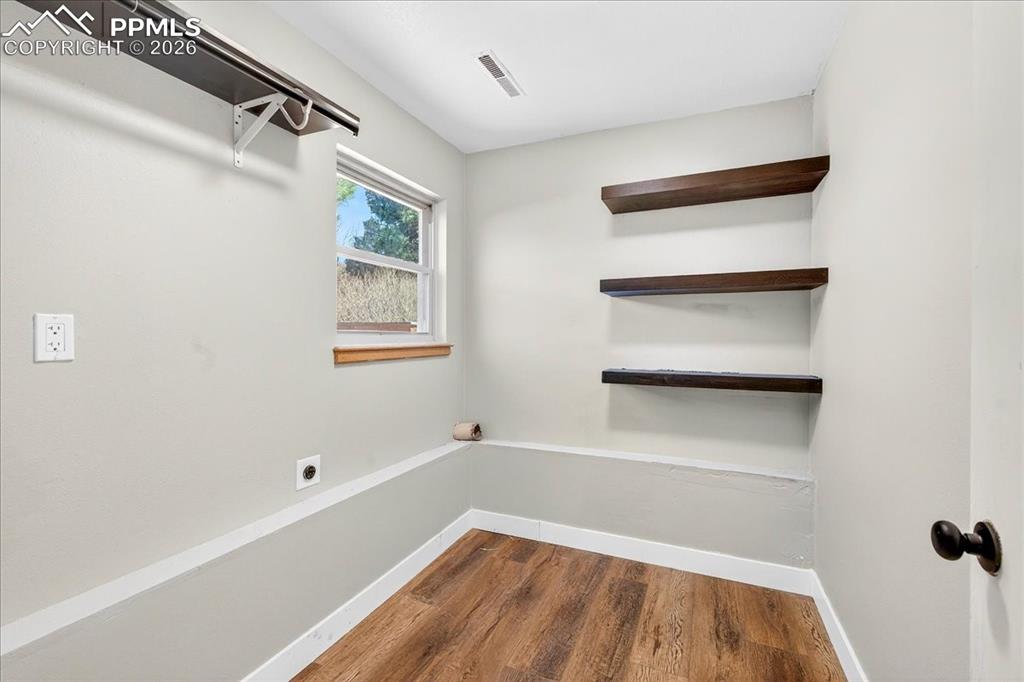 Image 24 of 49: Spare room with dark wood-type flooring and baseboards