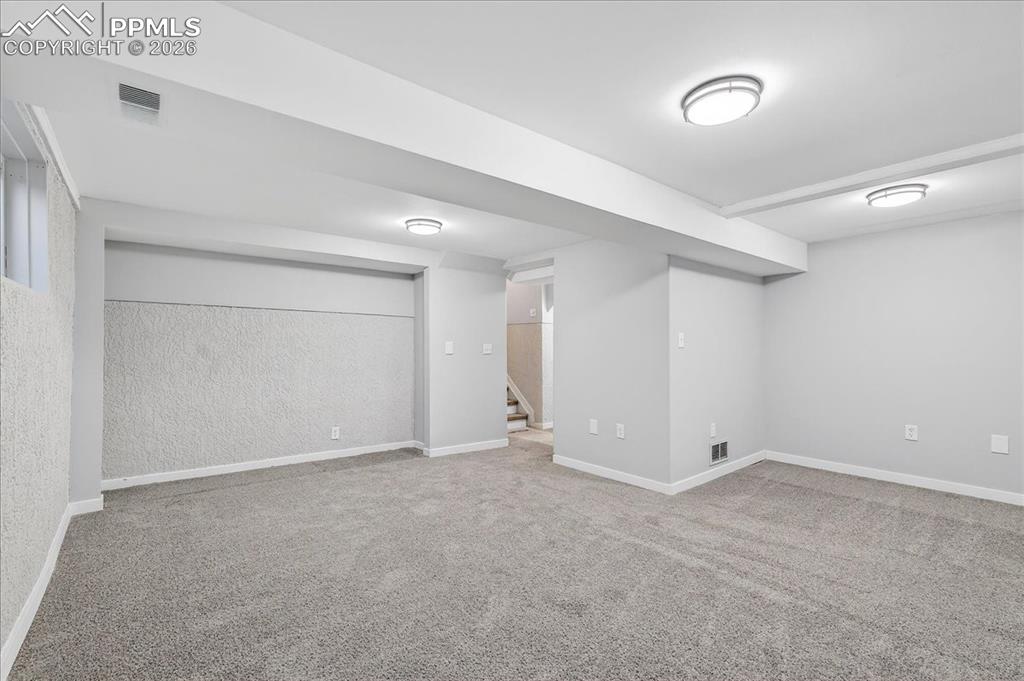 Image 33 of 49: Finished basement featuring baseboards and light carpet