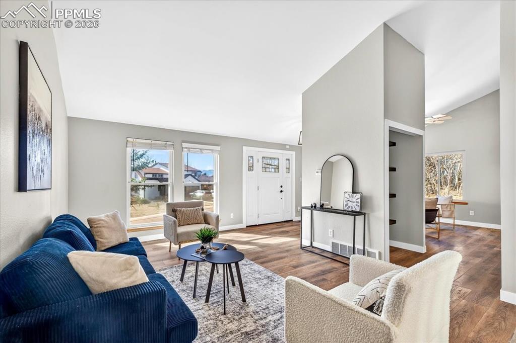 Image 5 of 49: Living area featuring wood finished floors and vaulted ceiling